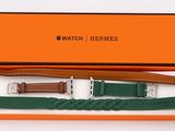 an orange box with two watches and a green strap in it