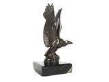 sculpture en bronze représentant un oiseau, posée sur un socle en marbre, sur fond blanc
