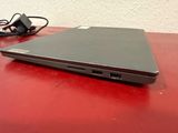a laptop computer sitting on a red table with a charger