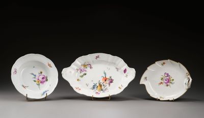 trois pièces de porcelaine ornées de motifs floraux, posées sur une table