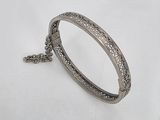 a close up of a bracelet with a chain on a white surface
