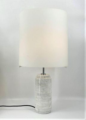 a lamp that is sitting on a table next to a vase