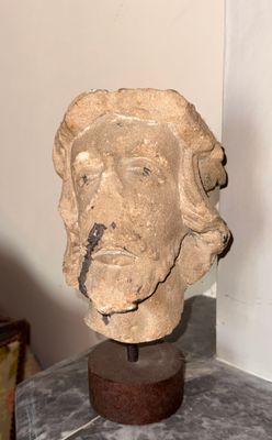 une statue représentant la tête d'un homme posée sur un socle de marbre