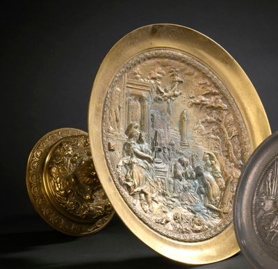 deux assiettes en or et en argent posées sur une surface noire