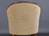 the back of a chair with a wooden frame and a beige upholstered seat
