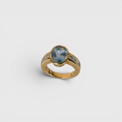 une bague en or sertie d'une topaze bleue et de diamants