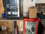 two soda coolers sitting next to each other in a room