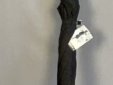 un parapluie noir muni d'une étiquette, accroché au mur