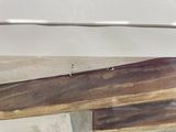 underside of a white boat with wood planks and nails on it