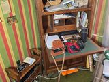 an image of a cluttered room with a desk and a chair