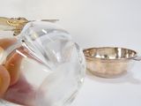 une personne en train de verser quelque chose dans un verre à l'aide d'une cuillère