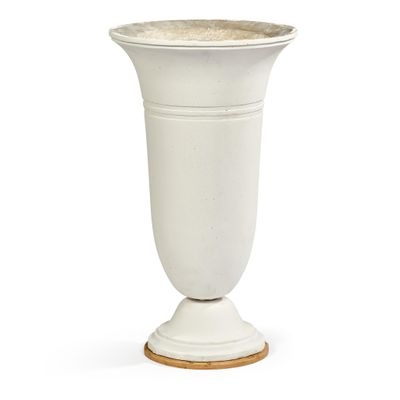 un vase blanc posé sur un socle en bois, sur un fond blanc