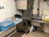 une cuisine avec un évier et un plan de travail sur lequel sont posés de nombreux plats