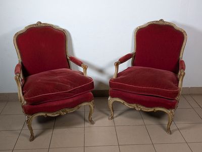 Deux fauteuils en velours rouge, en bois stuqué, laqué et doré. Dossie