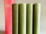 quatre livres sont alignés sur une surface blanche