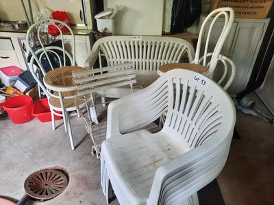 a lot of white chairs and tables in a garage