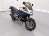 une moto bleue et blanche garée dans une pièce blanche