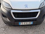 the front view of a white van parked in a parking lot