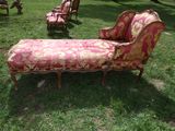a red and gold couch and a chair in the grass