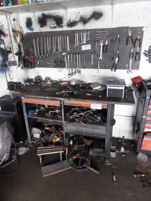 un garage équipé d'un établi, d'outils et d'un ventilateur