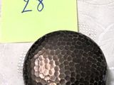 un petit objet noir posé sur une table près d'un poteau – note