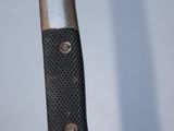 a close up of a knife with a black handle