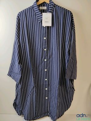 une chemise à rayures bleues et blanches suspendue à un cintre