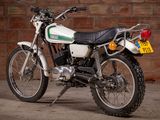 a white motorcycle parked in front of a brick wall