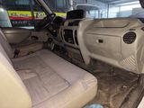 a dirty car inside of a building with the door open
