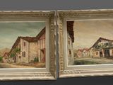 two paintings of old buildings are hanging on a wall