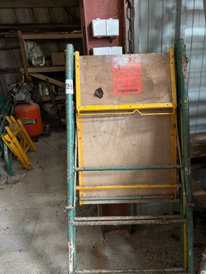 une photo d'une échelle dans un garage, sur laquelle se trouve une boîte