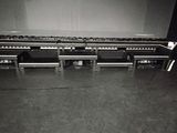 black and white photo of a piano in front of a large screen