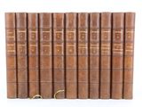 a set of six old leather books sitting on top of each other