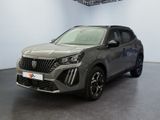 Le SUV gris est garé dans une grande pièce au sol noir.