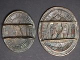 two old coins are sitting side by side on a black surface