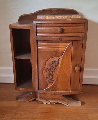 un petit meuble en bois orné d'un motif sculpté