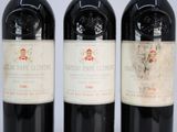 three bottles of red wine sit side by side on a table