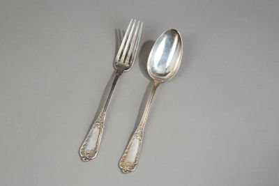 deux cuillères et une fourchette en argent sur une table