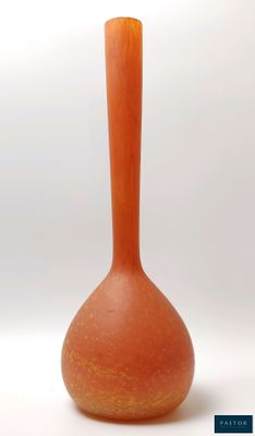 un petit vase orange posé sur une surface blanche