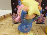 a small figurine of a girl holding a star on her head