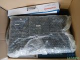 a cardboard box with a laptop in it that is wrapped in plastic