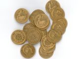 une pile de pièces d'or posée sur une surface blanche