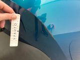 a hand that is holding a piece of paper near a car