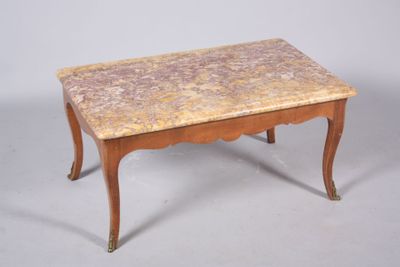 une table basse avec un plateau en marbre posée sur un piètement en bois