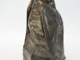 statue of a bird perched on a rock on a white background