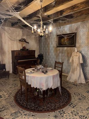 a dining room with a table and chairs and a piano