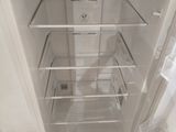 an empty refrigerator with its door open on the floor