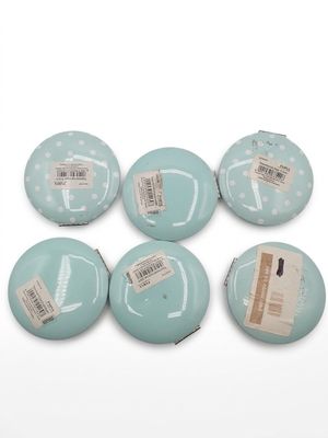 four blue buttons with white polka dots on them on a white surface