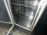 a silver oven sitting inside of a metal cabinet