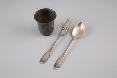 deux cuillères, une fourchette et une tasse posées sur une table
